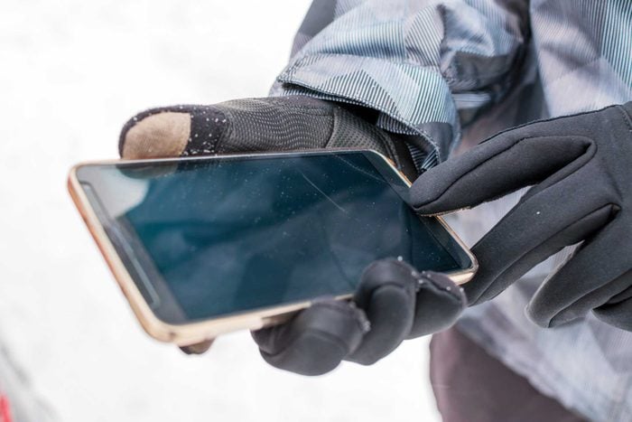 Person uses phone while wearing gloves