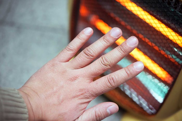 Person warming up hands on heater