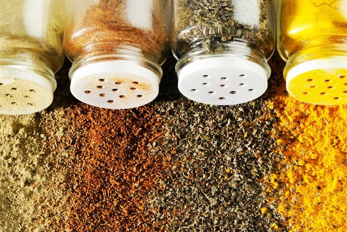 Spice jars spilling colorful spices on table