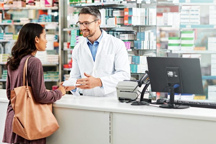 woman getting medicine from a pharmacist