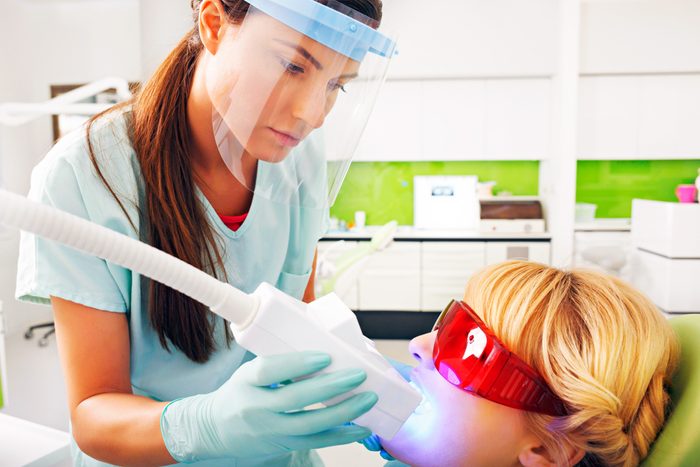dentist whitening a woman's teeth