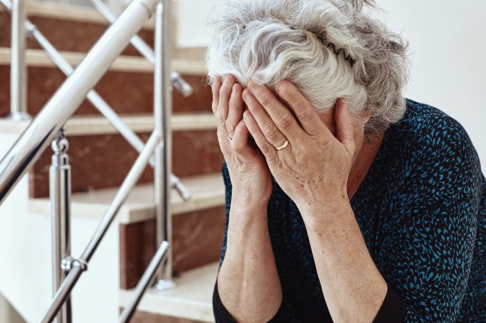 senior woman crying with head in hands
