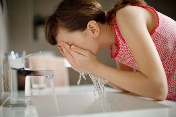 young girl washing face