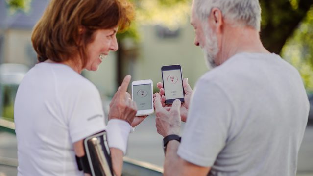 older couple using fitness app while exercising