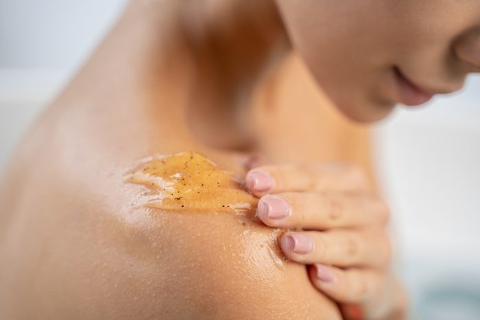 close up of woman applying body scrub