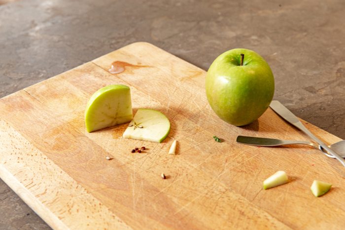 green apple on cutting board in kitchen