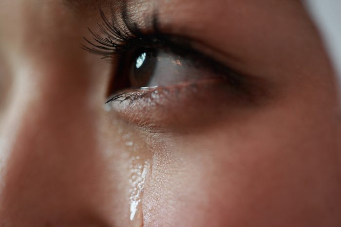 close up of tear streaming down young woman's face