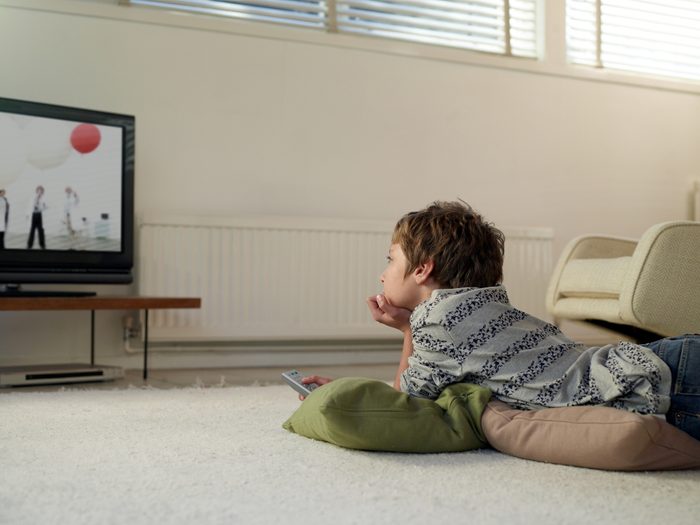 boy lying on floor watching television
