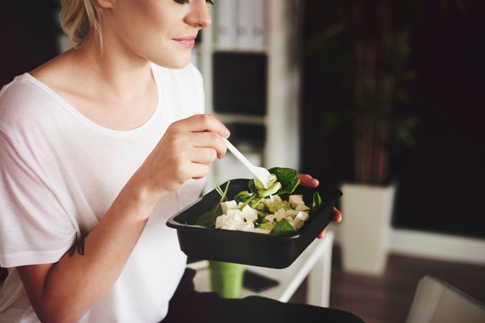 young woman eating a salad for lunch