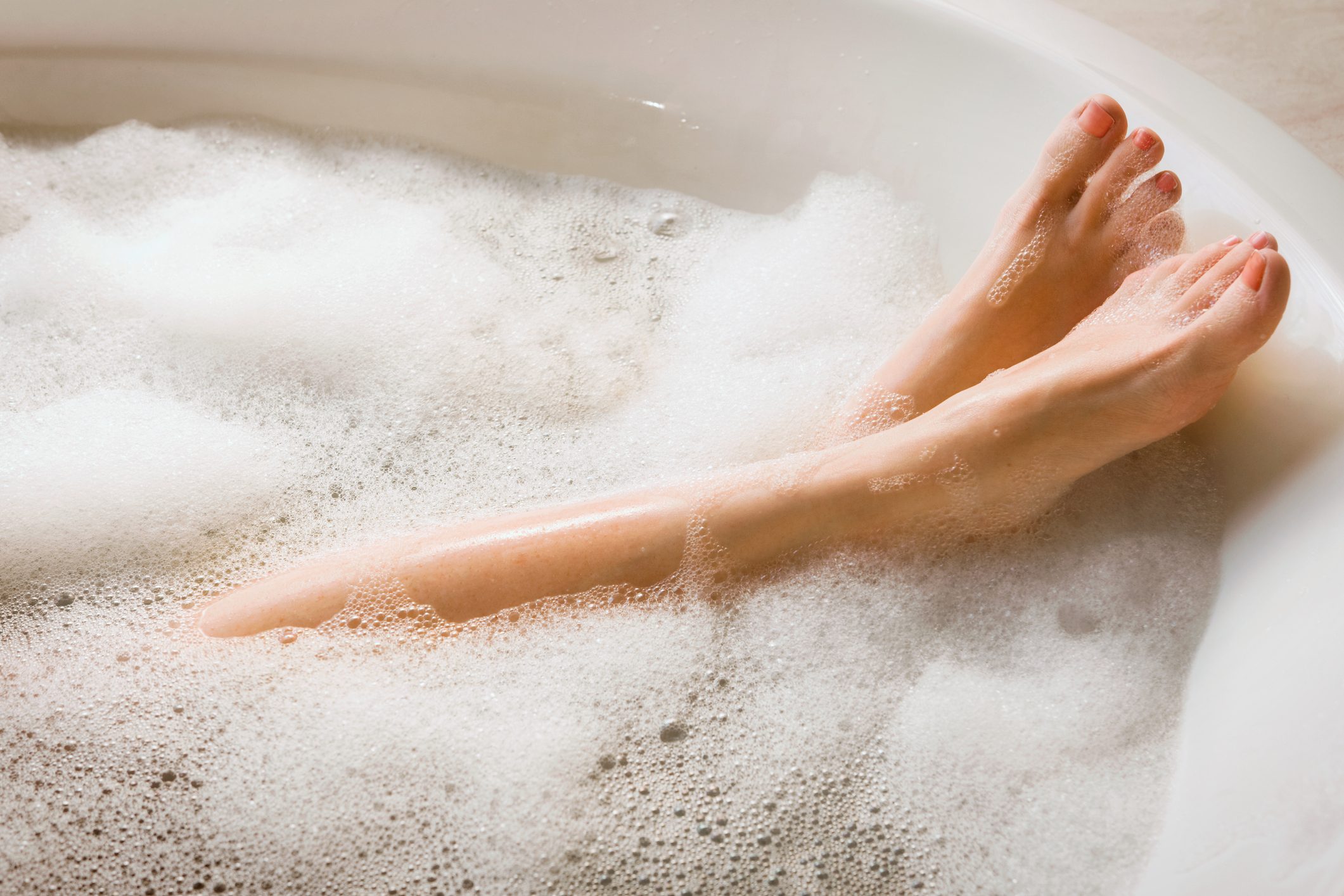 крупный план женских ног в мыльной ванне