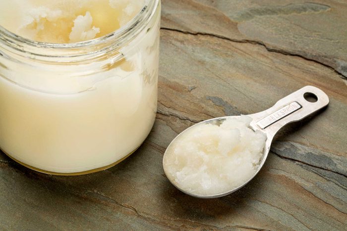 coconut oil in a jar next to a tablespoon