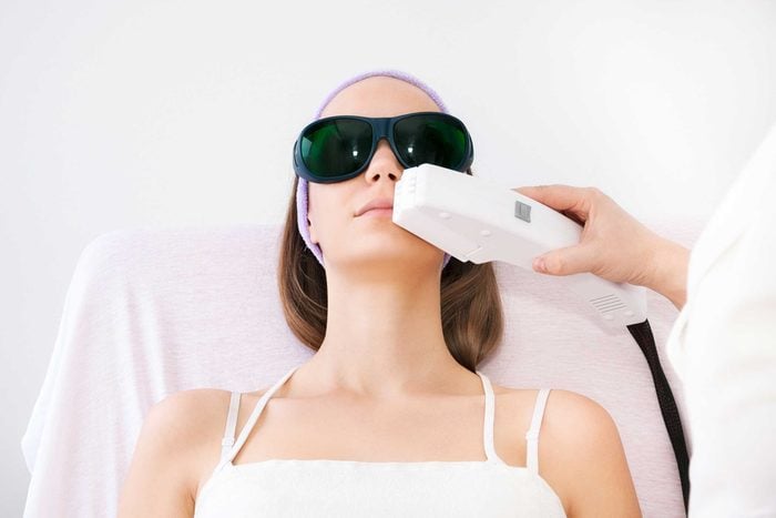 Woman in sunglasses getting laser/light treatment
