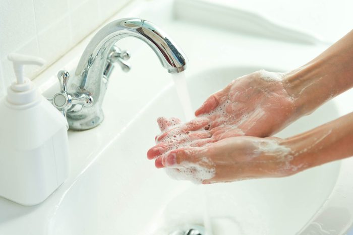person washing their hands at the sink