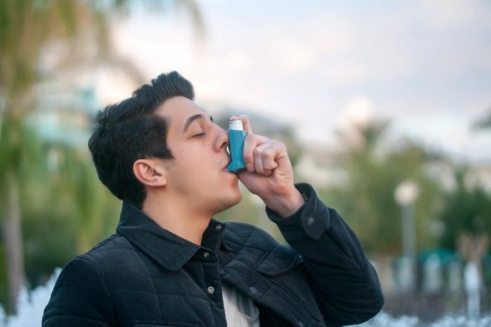 man outdoors using an inhaler