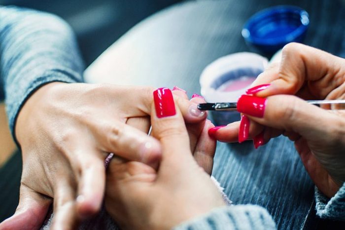 manicurist painting a person's nails