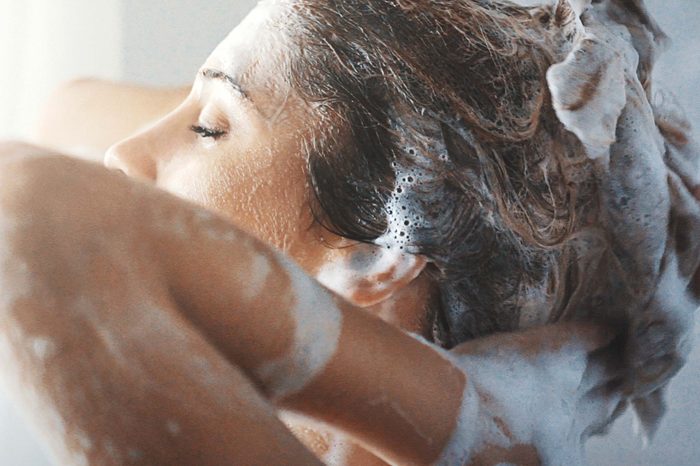 woman rinsing shampoo from hair