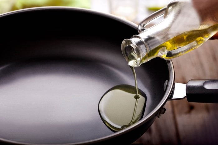 oil being poured into a cooking pan