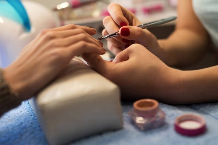 close up of a manicurist working on a customer's nails