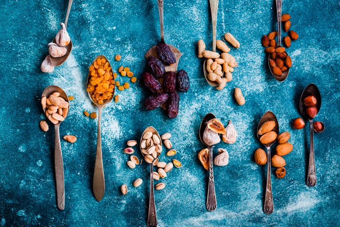 spoons with colorful variety of spices on blue cloth