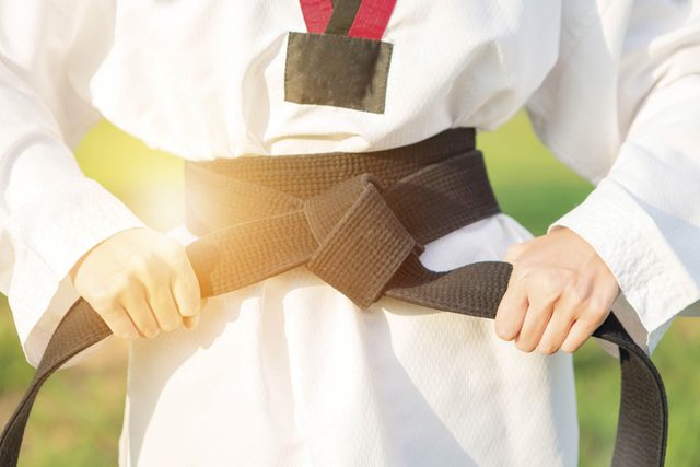 person tying on karate belt