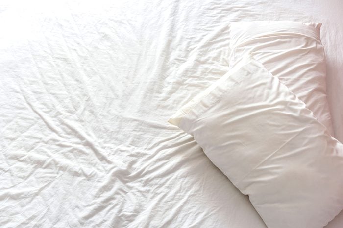 wrinkled bedsheets and pillows