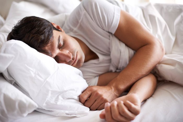 man sleeping on his side in bed