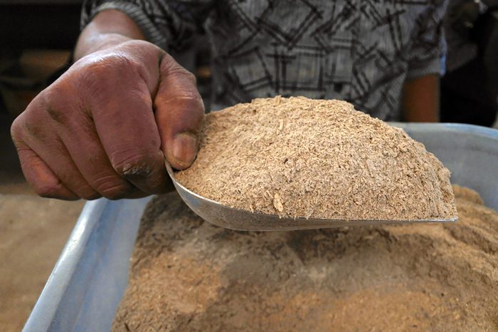 man with a scoop full of kava powder