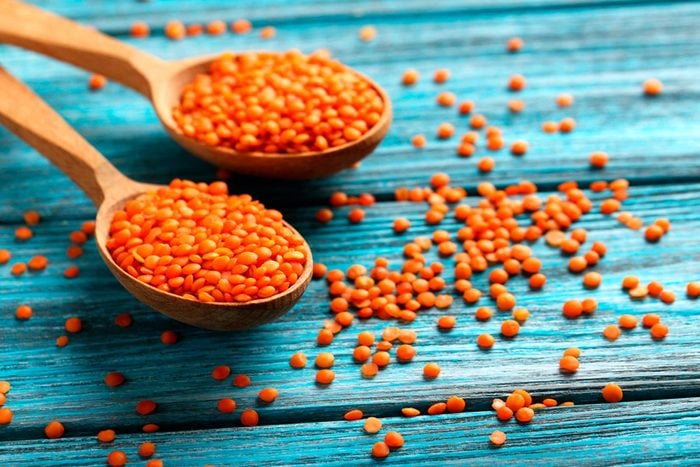 Spoonfuls of colorful orange-colored lentils