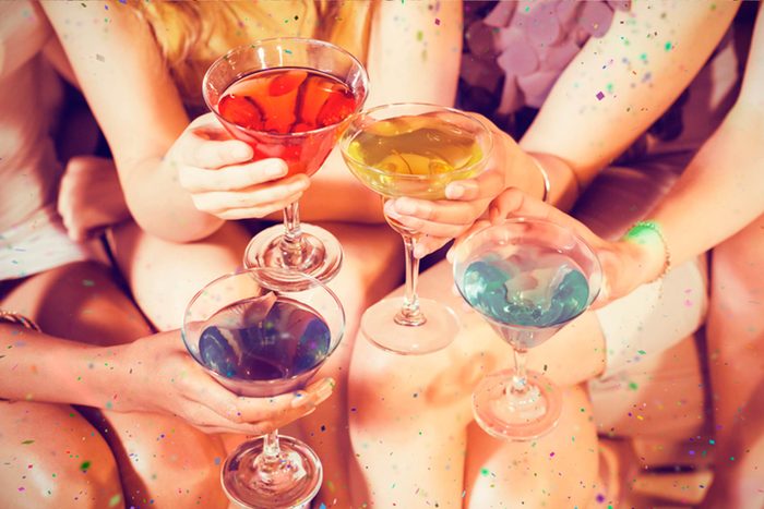 women toasting different colored cocktails