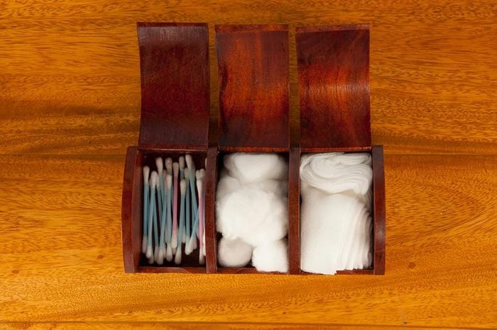 wooden box with cotton swabs, balls, and gauze