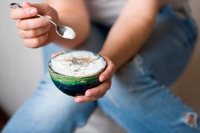 woman holding spoon and bowl of yogurt 