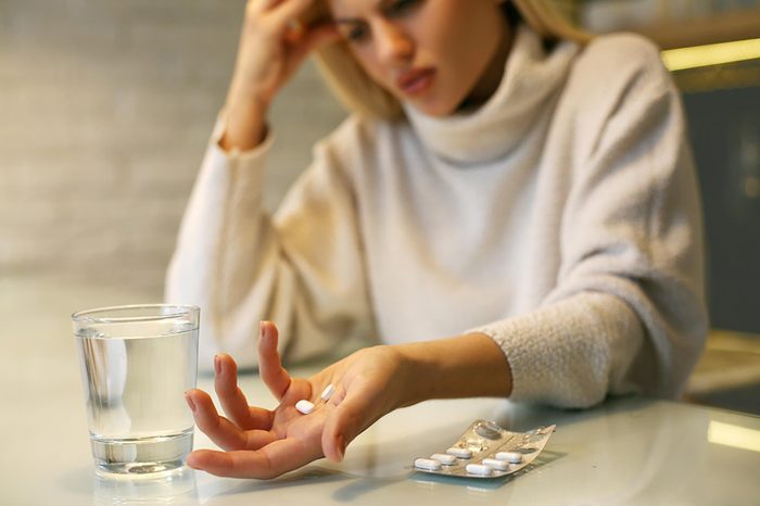 woman with pills and glass of water