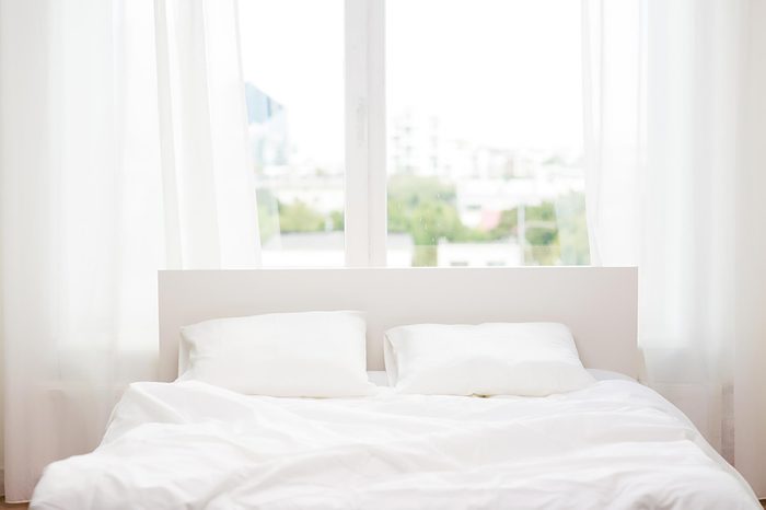 white bed in front of window