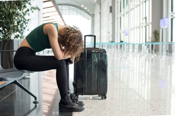 woman sitting in the airport waiting for delayed flight