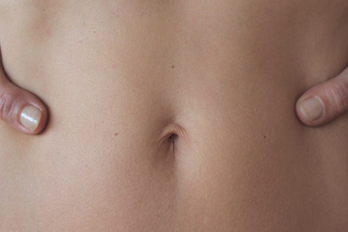 closeup of woman's stomach and belly button area
