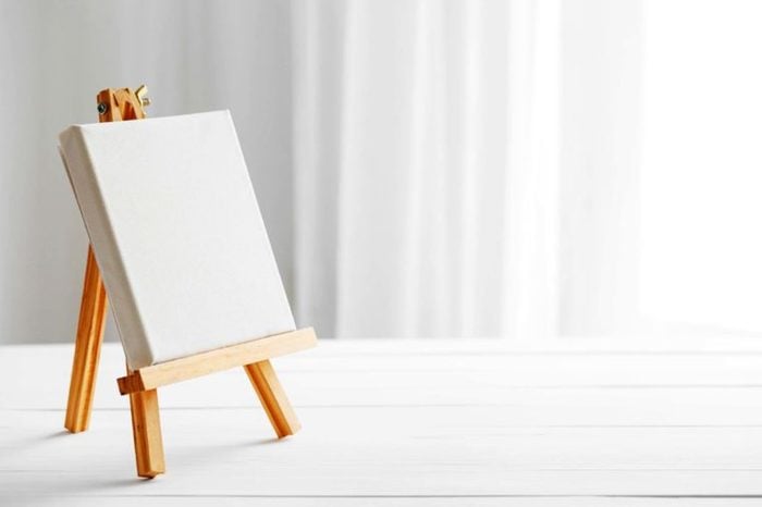 Blank easel in a white room.
