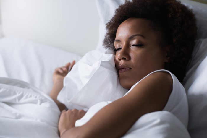 woman sleeping, holding her pillow