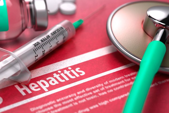 syringe and stethoscope over hepatitis info