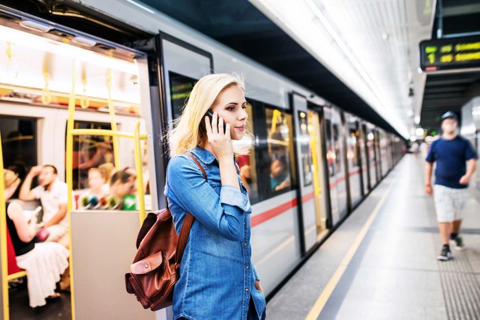 woman talks on phone as she departs commuter train
