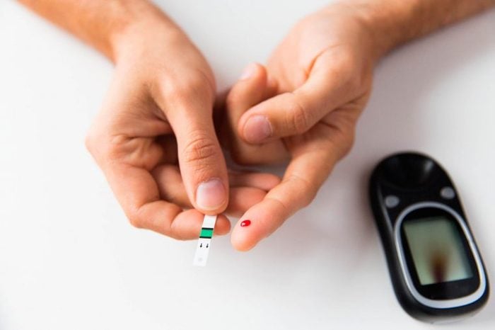 Person holding a diabetic glucose testing strip.