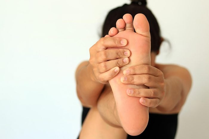 woman massaging foot for better circulation