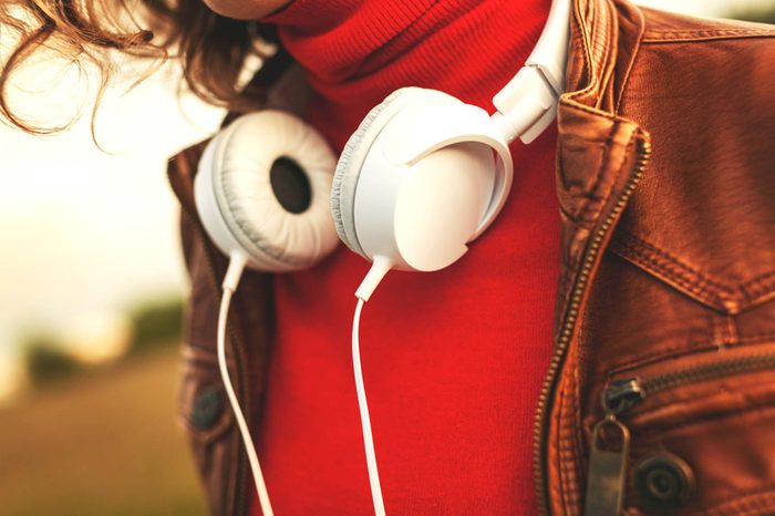 woman in red with headphones around neck