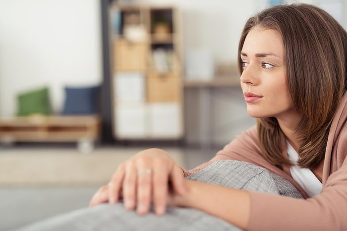 woman sitting on couch looking pensive