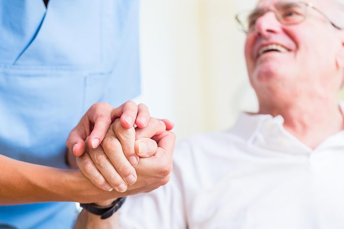 patient's hand held by healthcare worker