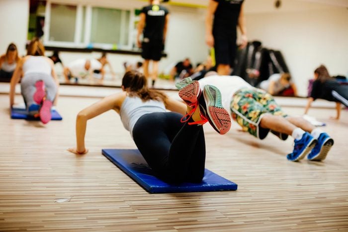 women and men in a workout class doing pushups