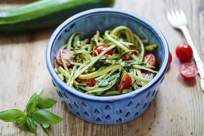 Bowl of zucchini noodles and cherry tomatoes.