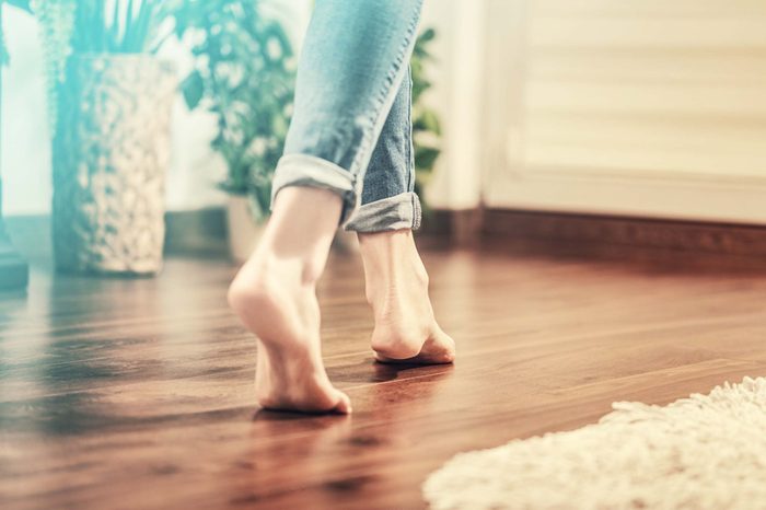 Woman walking barefoot on wood floor