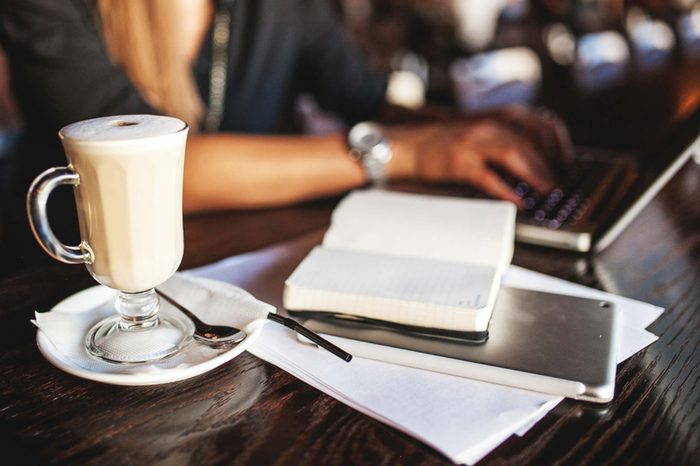 desk with coffee mug, notebook, laptop