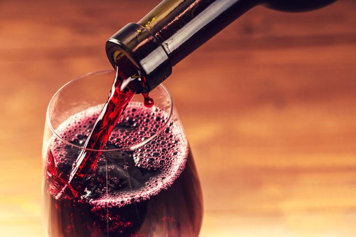 close up of red wine being poured from the bottle into a wine glass
