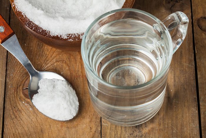 salt in spoon and water in glass mug